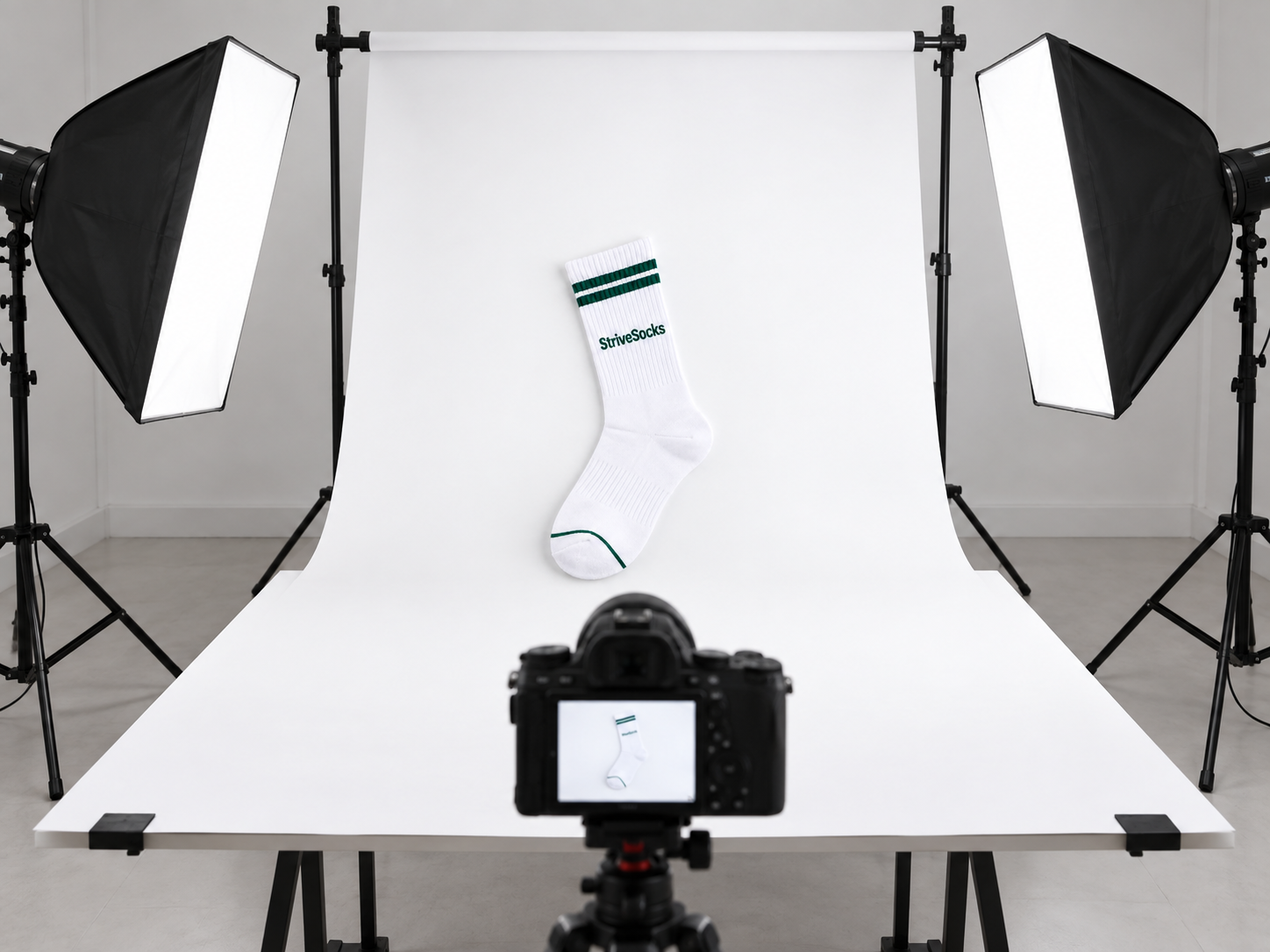 Sock product photography setup with camera, lights and white backdrop