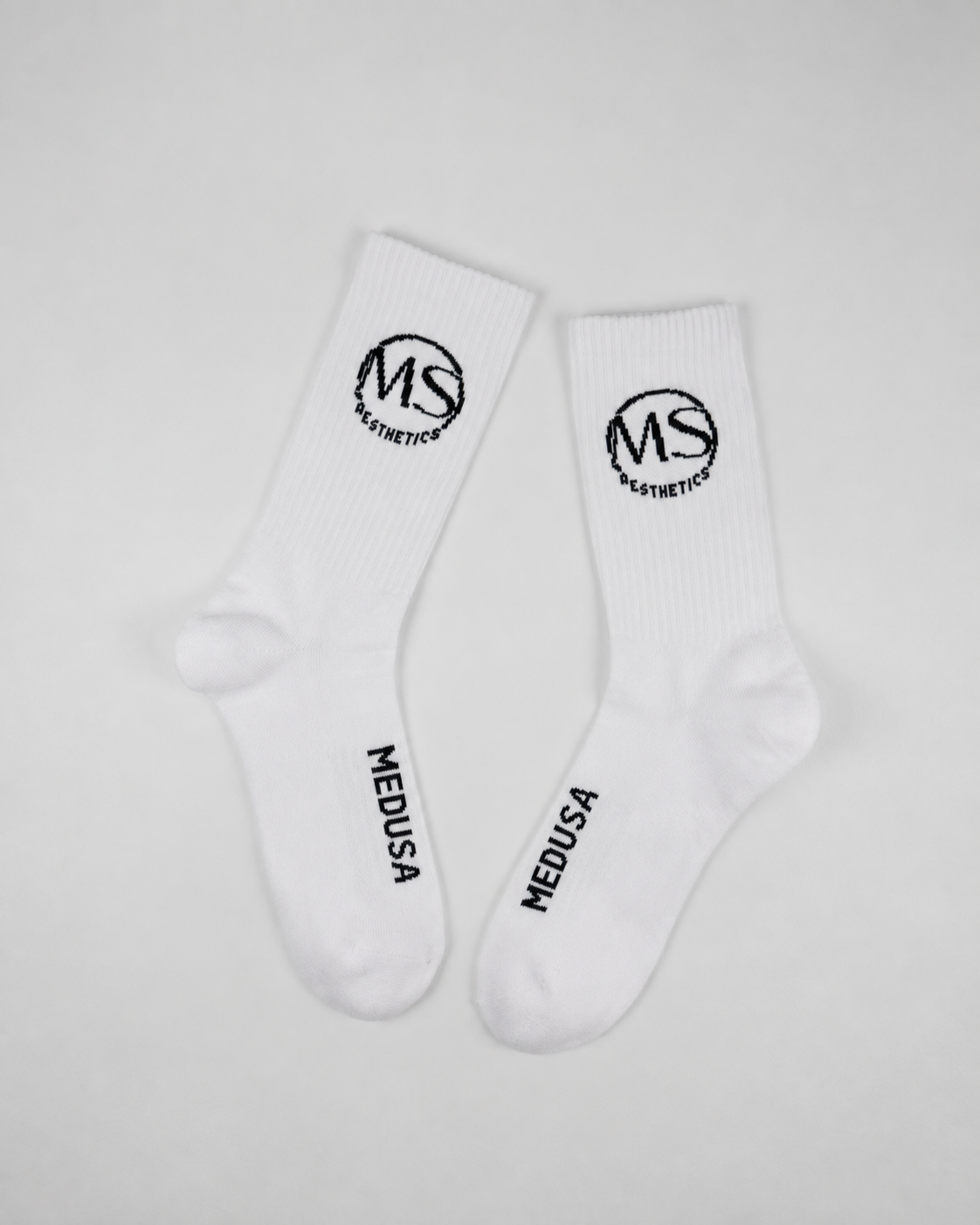 Pair of white branded sample socks shown in full