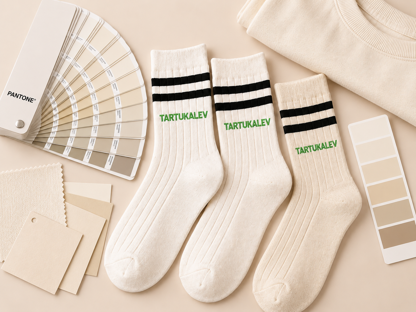 Cream crew sock samples compared beside neutral color swatches and apparel fabric