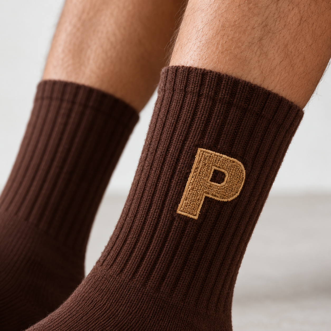 Close-up of the embroidered logo and rib knit on Essential Crew 01